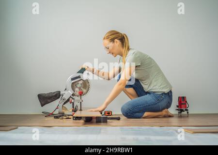 Couple marié installant un nouveau parquet stratifié en bois sur un plancher de film chaud.Système de chauffage au sol infrarouge sous sol stratifié Banque D'Images