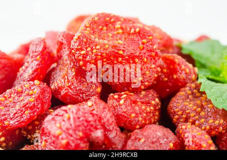 Fermez les fraises séchées dans un bol en bois avec des feuilles vertes. Banque D'Images