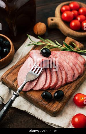 Délicieux saucisses faites maison coupées en morceaux sur une planche de bois Banque D'Images