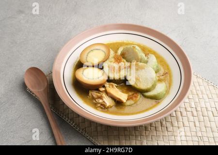 Lontong Opas, petit déjeuner traditionnel indonésien ou menu Eid.Opour fait de poulet cuit avec du lait de coco et des épices. Banque D'Images