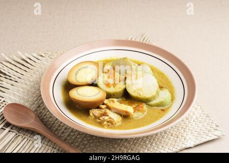 Lontong Opas, petit déjeuner traditionnel indonésien ou menu Eid.Opour fait de poulet cuit avec du lait de coco et des épices. Banque D'Images