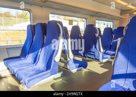 Intérieur d'un train de voyageurs avec sièges bleus vides Banque D'Images