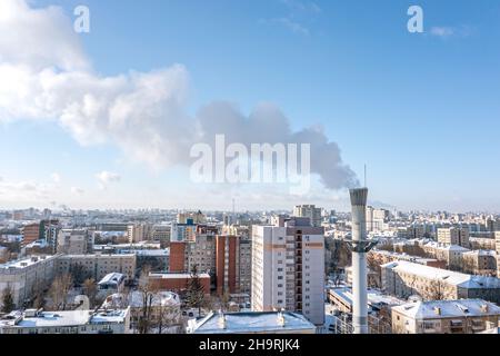 fumer la pipe de la centrale thermique contre le ciel bleu et le paysage urbain en hiver. photographie aérienne. Banque D'Images