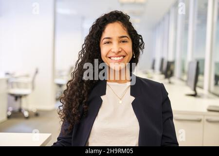 Une jeune femme heureuse en tant que fondatrice réussie d'une entreprise en démarrage dans le bureau Banque D'Images