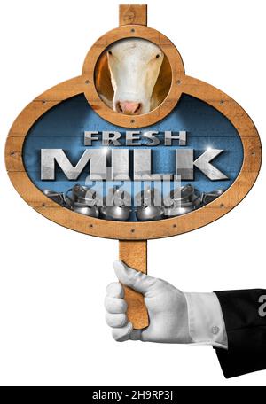 Main de serveur avec gant blanc tenant une enseigne en bois avec du texte lait frais, des canettes en acier pour le transport du lait et de la vache.Isolé sur un blanc. Banque D'Images