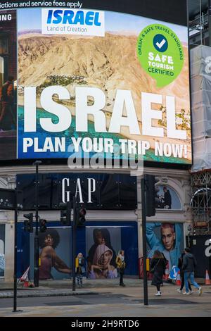 Les piétons marchent devant une publicité pour le tourisme israélien affichée sur un grand panneau électrique à Piccadilly Circus, Londres. Banque D'Images