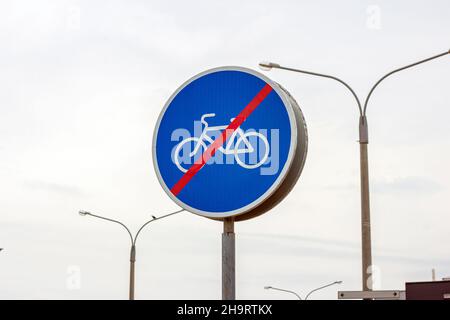 Panneau de signalisation bleu et blanc pour les pistes cyclables avec ligne rouge d'interdire indiquant la fin de la piste cyclable, grand panneau de signalisation routière circulaire. Banque D'Images