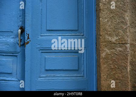 Ancienne porte en bois bleu avec une poignée en étain contre un mur en pierre à Nafplio, Grèce. Banque D'Images