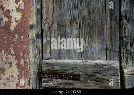 Ancienne porte en bois gris contre un mur de stuc patiné à Nafplio, Grèce. Banque D'Images