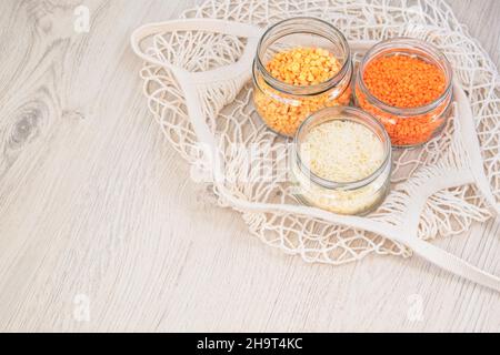 Grains et céréales dans zéro magasin de déchets.Stockage des aliments dans la cuisine à faible perte de vie.Lentilles, pois et riz en pots de verre sur fond de bois.ECO Banque D'Images