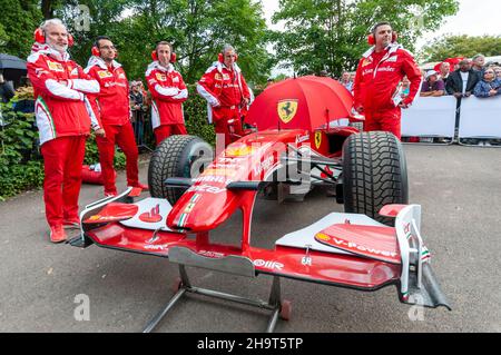 Ferrari Formula 1, Grand Prix, voiture de course dans la zone d'assemblage au Goodwood Festival of Speed, Royaume-Uni, 2016, avec l'équipage du stand attendant le temps de commencer Banque D'Images