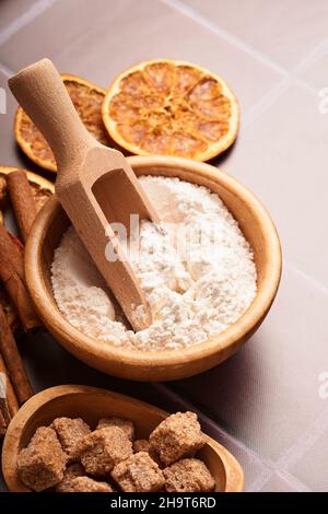 Fond de cuisson avec des ingrédients pour faire de la farine de pain d'épice, des œufs, des outils de cuisine, des ustensiles et des moules à biscuits sur une table en bois brun clair.Maquette Banque D'Images