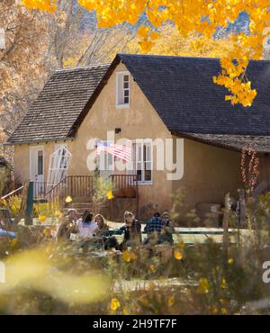 Fruita, parc national de Capitol Reef, Utah, États-Unis.Les visiteurs se détendent dans les jardins de Gifford House, qui fait partie de la ferme historique de Gifford, en automne. Banque D'Images