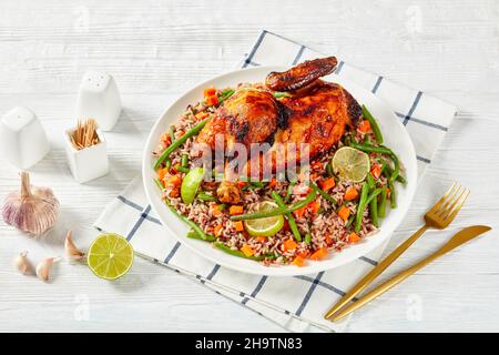 Poulet grillé au charbon de bois avec du riz frit aux légumes et du riz sauvage sur un plateau Banque D'Images