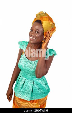 belle jeune femme vêtue d'une tenue traditionnelle, écoutant quelque chose en mettant sa main sur l'oreille tout en souriant. Banque D'Images
