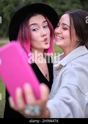 deux amis qui s'amusent à prendre un selfie en faisant des gestes de lèvre Banque D'Images