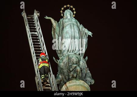 Rome, Italie.08th décembre 2021.Un pompier prend une couronne sur la colonne de la Vierge Marie pendant la fête annuelle.Hommage traditionnel des pompiers à la Vierge Marie de la pose de couronne sur la colonne de Piazza di Spagna pendant la fête annuelle de l'Immaculée conception à Rome.Crédit : SOPA Images Limited/Alamy Live News Banque D'Images