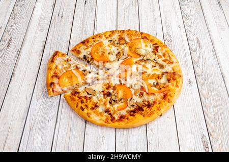 Pizza fraîchement préparée avec des ingrédients et de la viande de kebab ou de shawarma avec du fromage, des poivrons et beaucoup d'oignons et cuits dans un four à pierre. Banque D'Images