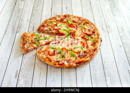 Délicieuse pizza en pierre colorée avec poivrons rouges et verts et fromage mozzarella avec bacon Banque D'Images