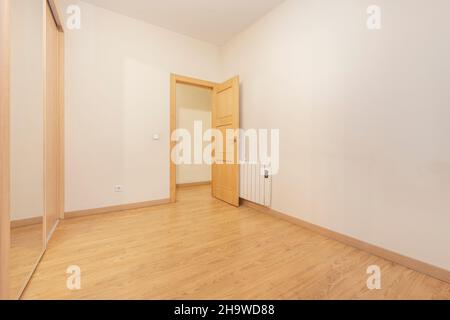 Chambre vide avec armoire intégrée avec porte miroir et chauffage électrique Banque D'Images