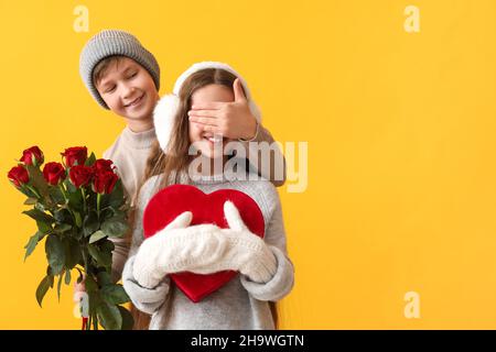 Un petit garçon saluait son ami le jour de la Saint-Valentin sur fond de couleur Banque D'Images