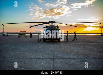 Les soldats du 3rd Bataillon « cauchemar » de l'hélicoptère d'assaut, 1st Aviation Regiment, 1st combat Aviation Brigade (1Cab), 1st Infantry Division travaillent ensemble pour plier les lames d'un hélicoptère UH-60 Black Hawk alors que le soleil se couche au port d'Alexandroupoli, Grèce, le 20 novembre 2021.Le 1Cab se préparait à charger l'avion sur le navire de navigation ARC Independence, puisqu'ils ont été remplacés par la Brigade de cavalerie aérienne de 1st, division de cavalerie de 1st.(É.-U.Photo de l'armée par le sergent d'état-major.Jennifer Reynolds/PUBLIÉE) Banque D'Images