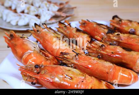 Gros plan sur une assiette blanche de délicieuses crevettes de rivière grillées flamboyantes Banque D'Images