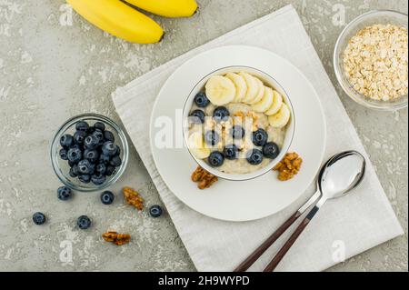 flocons d'avoine avec banane, bleuets et noix pour un petit déjeuner sain. vue du dessus Banque D'Images