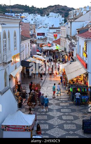 Portrait de la R 5 de Outubro shopping street dans la soirée avec les touristes appréciant les paramètre, Albufeira, Portugal, Europe. Banque D'Images