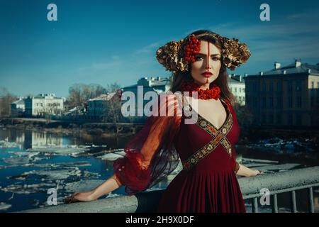 Jeune fille guerrier pose avec un couteau portant une robe rouge Banque D'Images