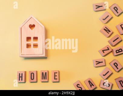 Mot home, pris d'une pile de blocs de lettres en bois et d'une maison en bois Banque D'Images