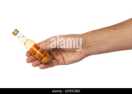Petite bouteille de whisky à la main isolée sur fond blanc, modèle pour les concepteurs Banque D'Images