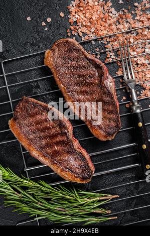 Rôti de chapeau grillé au barbecue ou bifteck de bœuf au sirloin du haut, viande frite sur le gril.Arrière-plan noir.Vue de dessus Banque D'Images