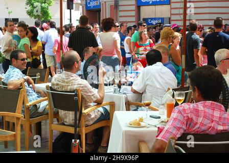 Les gens se détendent dans un café sur le trottoir pendant la foire de Malaga, Malaga, Espagne. Banque D'Images