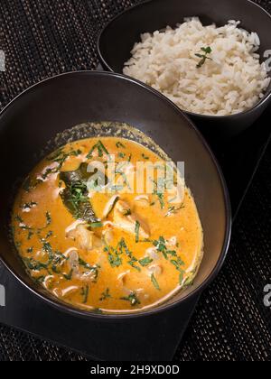 Nourriture indienne - poulet au beurre, nourriture épicée au curry avec riz, photo verticale sur fond sombre Banque D'Images