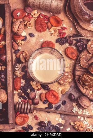 café et fruits secs. aliments sains pour le cœur, abricots séchés, noix, bonbons faits maison de flocons d'avoine.Arrière-plan rétro Banque D'Images