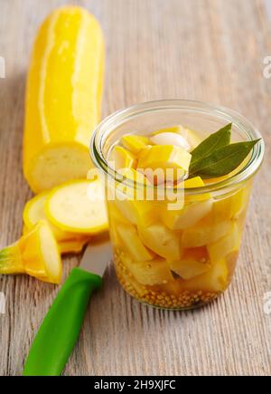 Courgettes jaunes marinées avec feuilles de Laurier, moutarde, vinaigre et sucre dans un pot Banque D'Images