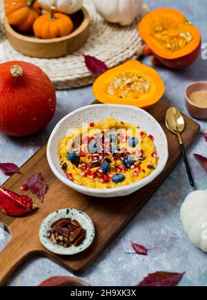 Porridge de millet et de citrouille, servi avec des graines de grenade et des bleuets Banque D'Images