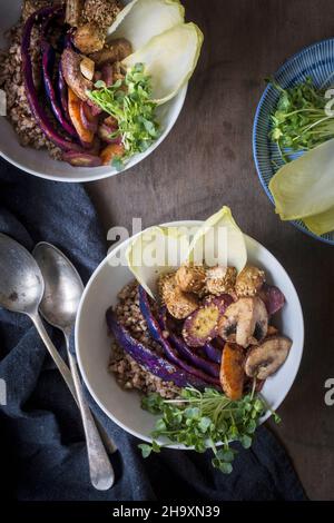 Sarrasin, légumes, tofu de graines de sésame et cresson dans des bols sur une table en bois avec un linge de lin et des cuillères millésimes Banque D'Images