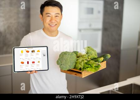 Man show en ligne magasin de nourriture et boîte avec des légumes Banque D'Images