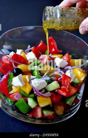 Vinaigrette versée sur une salade de légumes Banque D'Images