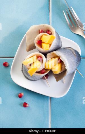 Rollmops (filets de hareng marinés) avec des graines de mangue et de grenade Banque D'Images