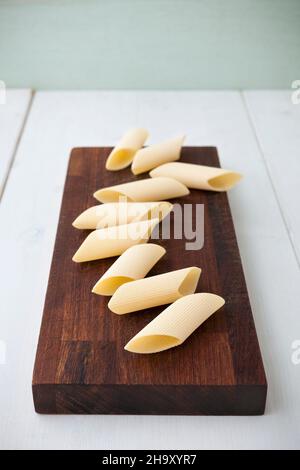 Penne rigate sur une planche en bois Banque D'Images