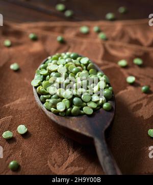 Petits pois verts séchés sur une cuillère en bois Banque D'Images