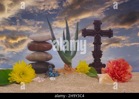 Croix et fleurs sur sable avec l'usine de Vera d'aloès Banque D'Images