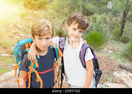 Deux enfants de randonnée avec leurs sacs à dos dans la brousse heureux d'atteindre la fin de la piste.Des scouts de garçons qui ont fait de la randonnée dans la forêt Banque D'Images