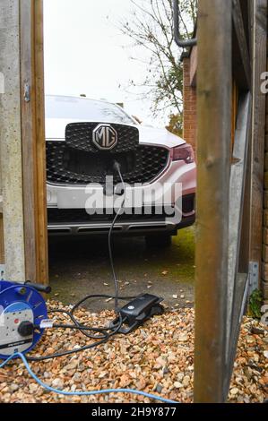 MG ZS EV en charge à la maison avec un chargeur granny utilisant un câble d'extension, les fabricants insistent pour ne pas utiliser de câbles d'extension mais de nombreux utilisateurs doivent les utiliser. Banque D'Images