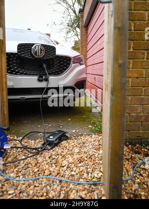 MG ZS EV en charge à la maison avec un chargeur granny utilisant un câble d'extension, les fabricants insistent pour ne pas utiliser de câbles d'extension mais de nombreux utilisateurs doivent les utiliser. Banque D'Images