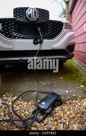 MG ZS EV en charge à la maison avec un chargeur granny utilisant un câble d'extension, les fabricants insistent pour ne pas utiliser de câbles d'extension mais de nombreux utilisateurs doivent les utiliser. Banque D'Images