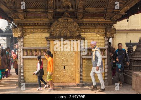 Les fidèles hindous tournent les roues de prière sur le temple de Harati Devi dans le complexe de temple de Swayambhunath à Katmandou, au Népal. Banque D'Images